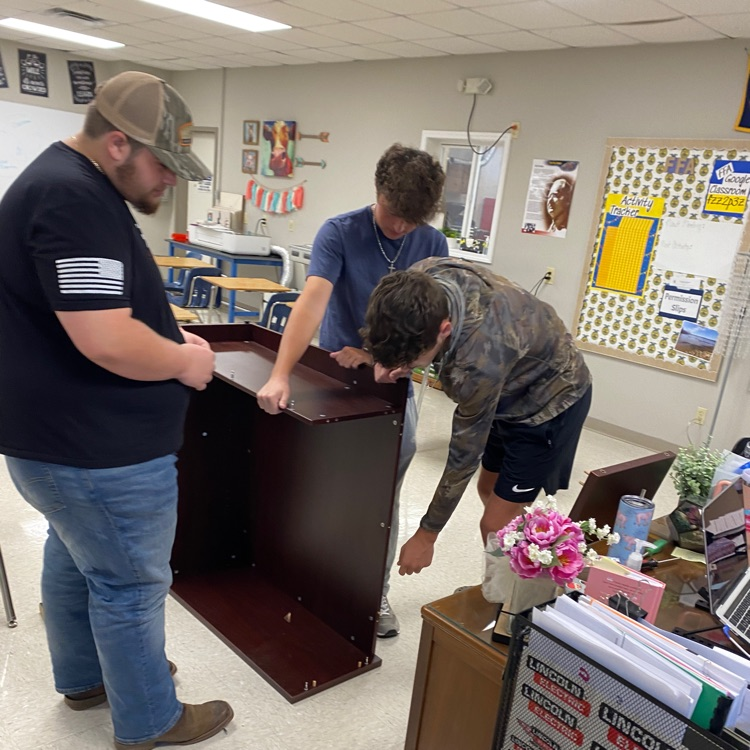  students putting together furniture/equipment 